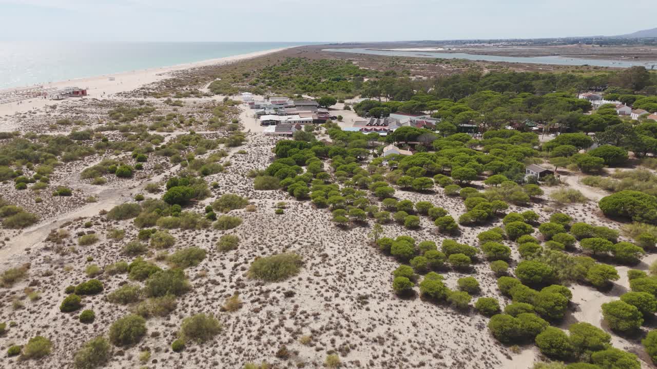 Smoothly rising to reveal the full extent of Tavira Island, highlighting its beaches, greenery, and Atlantic coastline