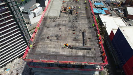 drone top shot of building and construction workers on highrise