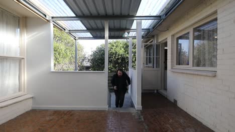 young man walking back up stairs onto empty patio setting