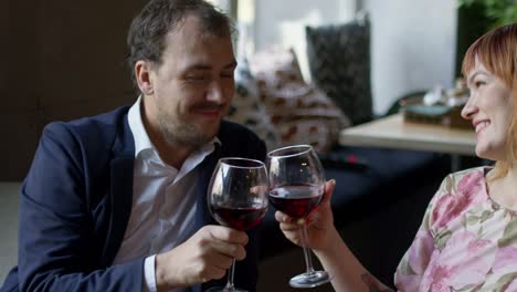 couple drinking wine and kissing on date