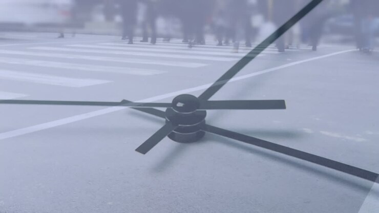 People crossing the street with clock in the foreground