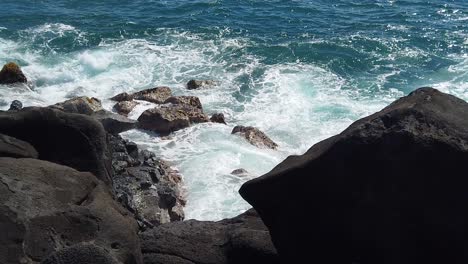 hd slow motion hawaii kauai looking down to ocean waves swirling and building and crashing on rocks below with lava rocks in v shaped foreground take four