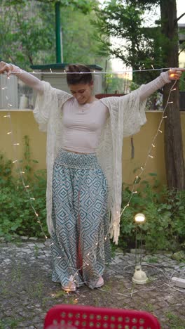 woman enjoying fairy lights in her garden