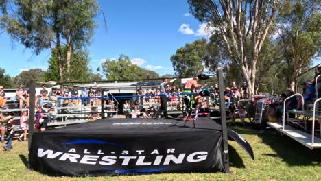 spectators watching a wrestling match outdoors