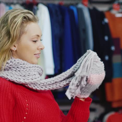 attractive woman in a red sweater tries warm mittens 1