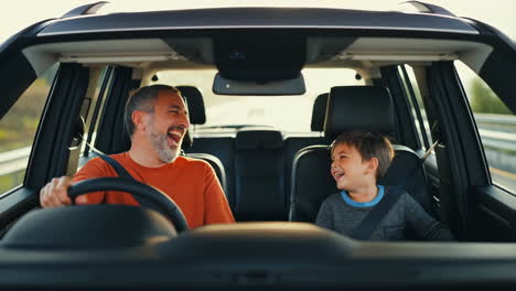 father and son sharing a happy moment while driving in a car