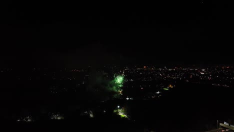 disparo aéreo de grandes fuegos artificiales verdes explotando en el cielo nocturno en los años nuevos