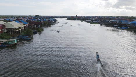 aerial view of a sprawling stilt village with blue rooftops stretching along tonlé sap’s waterways