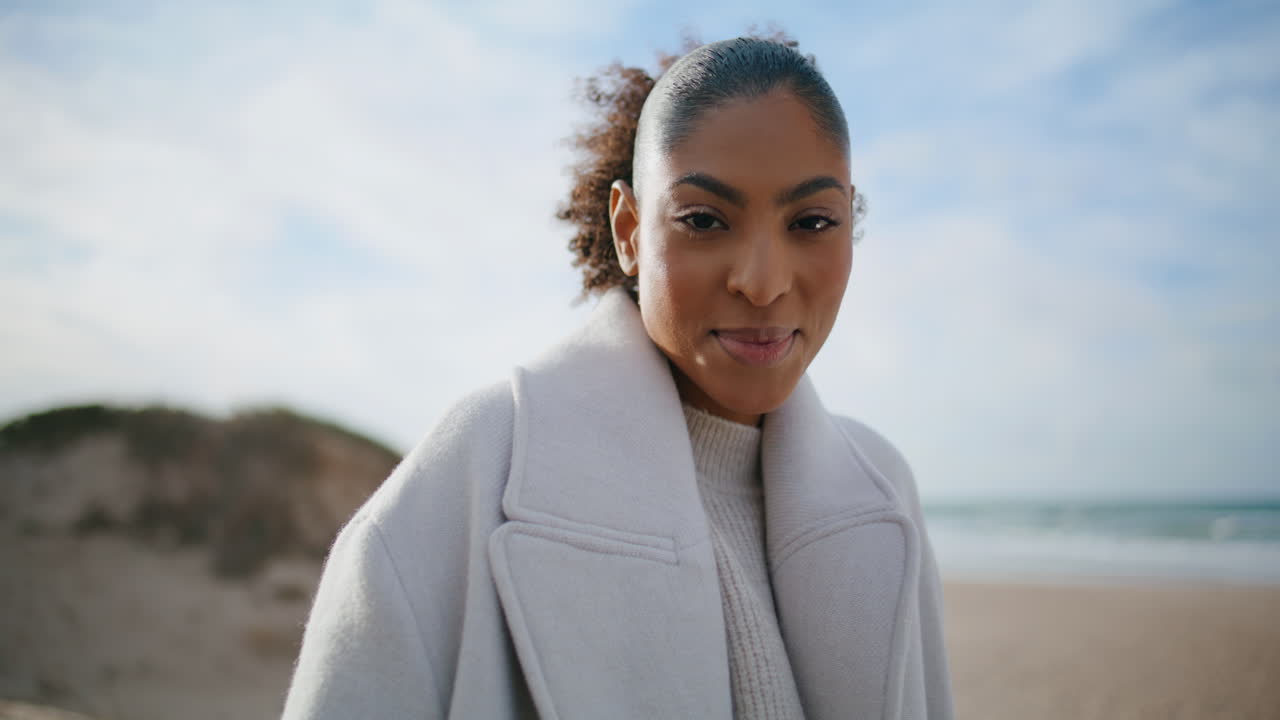 Closeup cheerful woman laughing at autumn beach. Happy curly girl relaxing shore