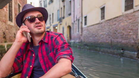 man talking on phone in a gondola in venice