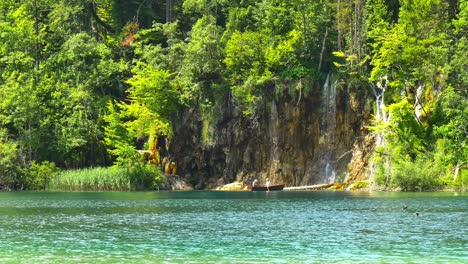 Pareja-Descansando-En-Un-Bote-Pequeño-Junto-A-Una-Cascada-En-El-Parque-Del-Lago-Nacional-De-Plitvice