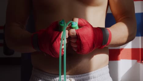 vista de cerca del hombre con cuerda de saltar en el gimnasio de boxeo