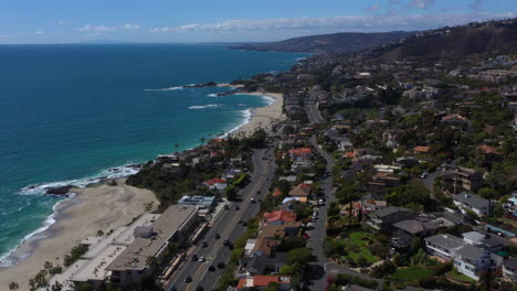 Gorgeous-Aerial-forward-Laguna-Beach-coastline-village-and-highway,-California