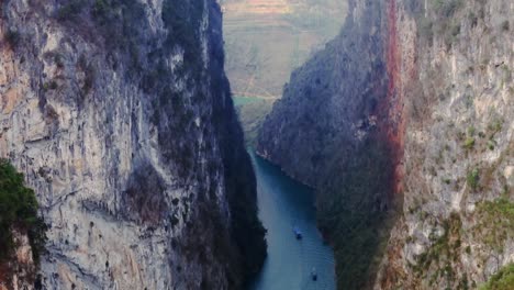 the drone flies through the canyon, revealing towering cliffs and the serene, winding river below