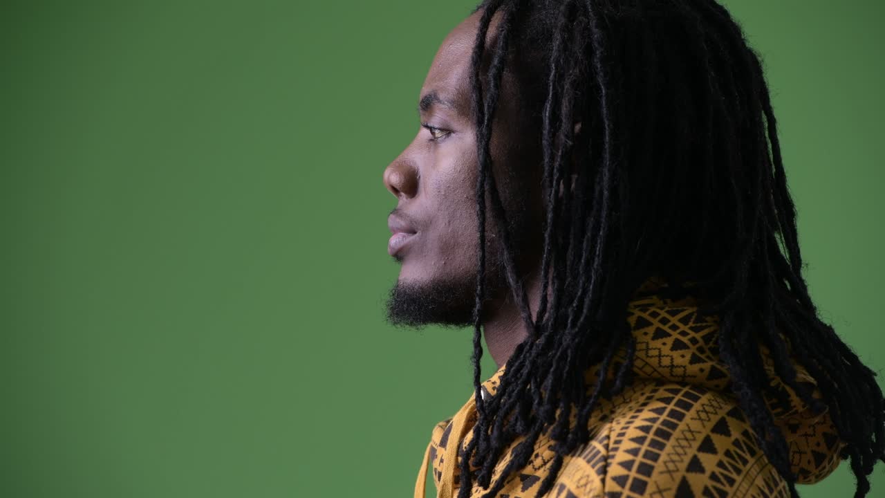 초록색 배경 에 드레드 머리카락 을 가진 젊은 잘생긴 아프리카인