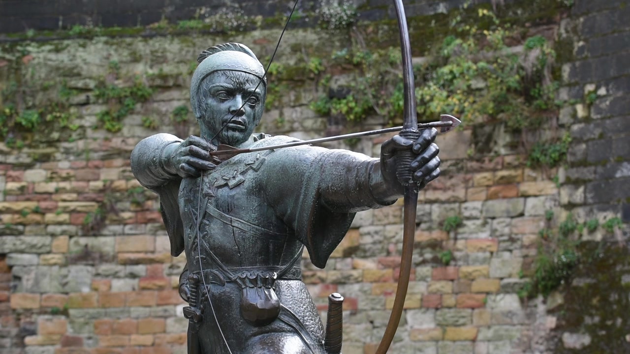 La statua di Robin Hood si erge fiera su Castle Road a Nottingham, Inghilterra, puntando la sua freccia verso lo storico corpo di guardia del Castello di Nottingham