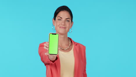 mujer presentando un teléfono inteligente de pantalla verde