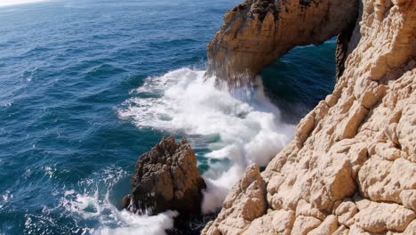 ocean waves crashing against coastal arch