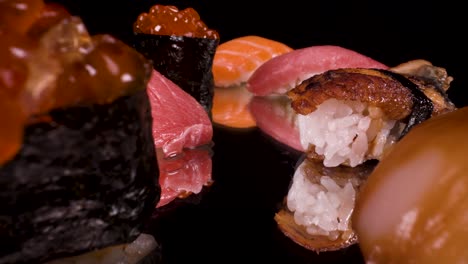 macro view moving past nigiri sushi on reflective black glass, toro tuna, salmon, ikura, lemon fish and unagi, hand-formed japanese food