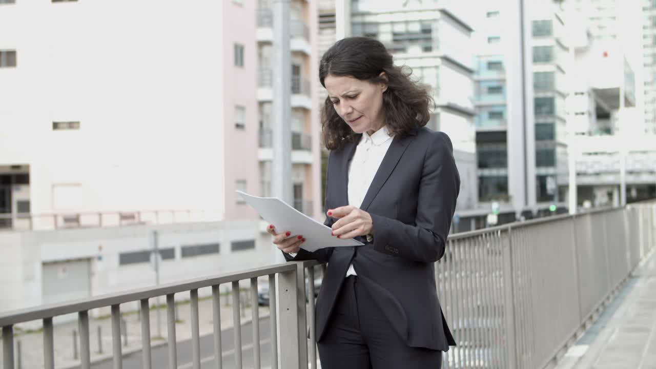 Empresaria leyendo documentos en la calle