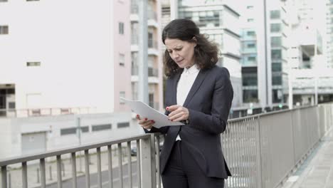 businesswoman reading papers on street