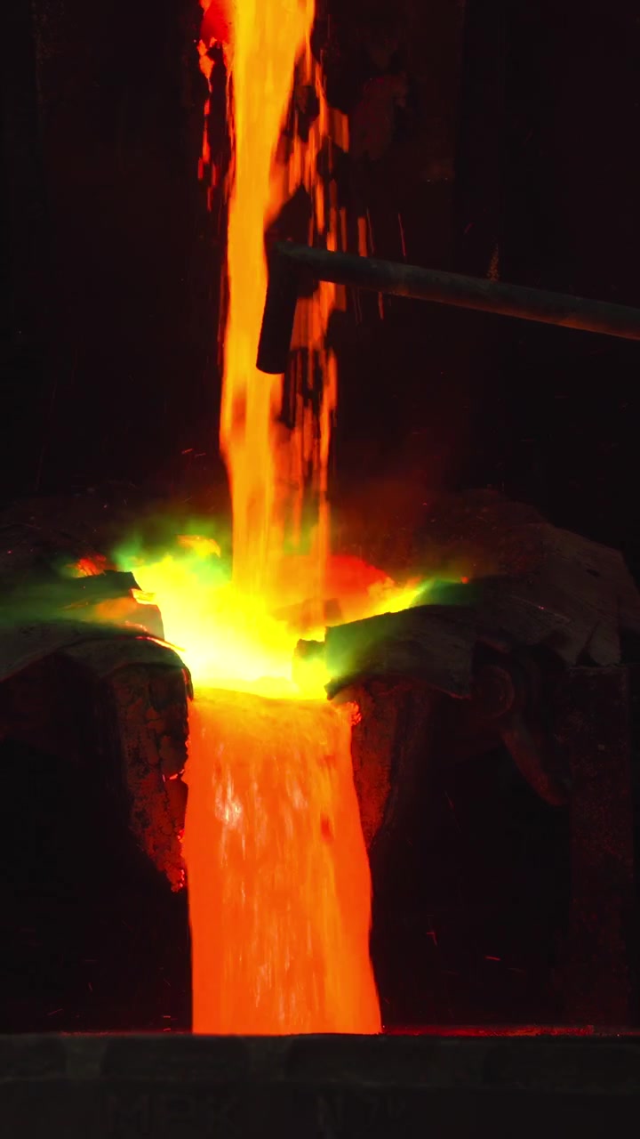Flusso continuo di metallo fuso che si riversa nella siviera, canalizzazione e contenimento controllati del metallo fuso con bagliore intenso.