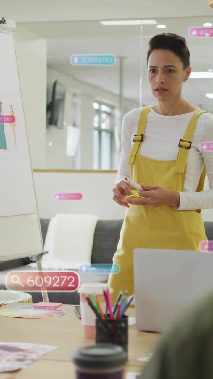 Vertical video: Designer placing sticky notes during talk as UI tags tagging sketches to align team