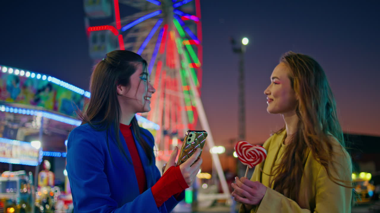 즐거운 소녀들이 놀이 공원에서 셀피를 찍습니다. 행복한 가장 친한 친구들이 드폰 사진을 찍습니다