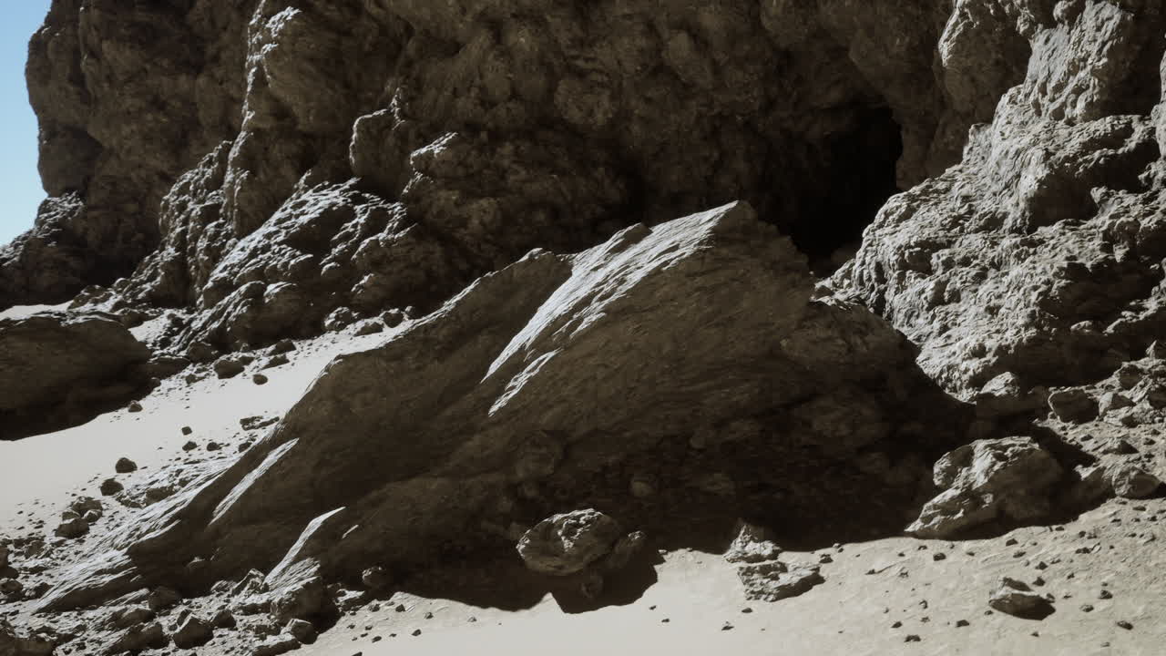 un paisaje desértico escarpado con una entrada a una cueva