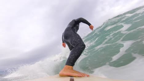 young male surfer rides the ocean wave in europe