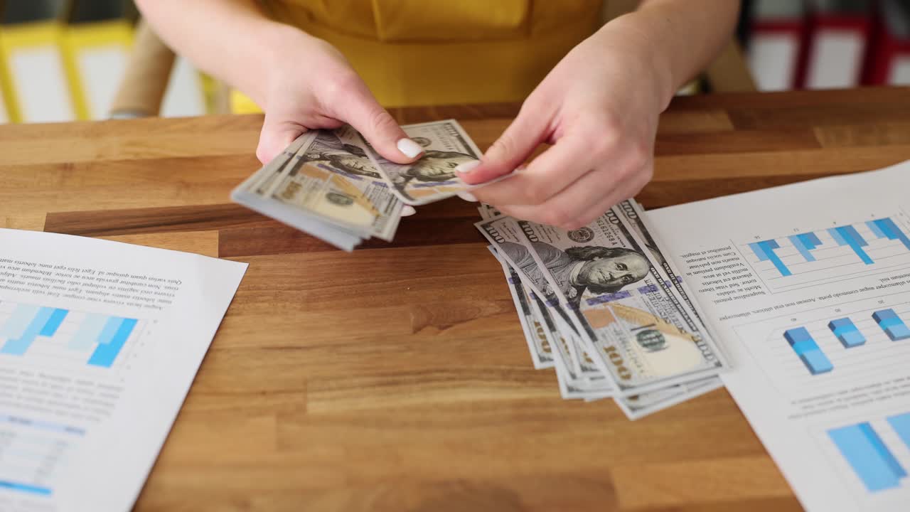 Hands Counting Stacks of Hundred Dollar Bills