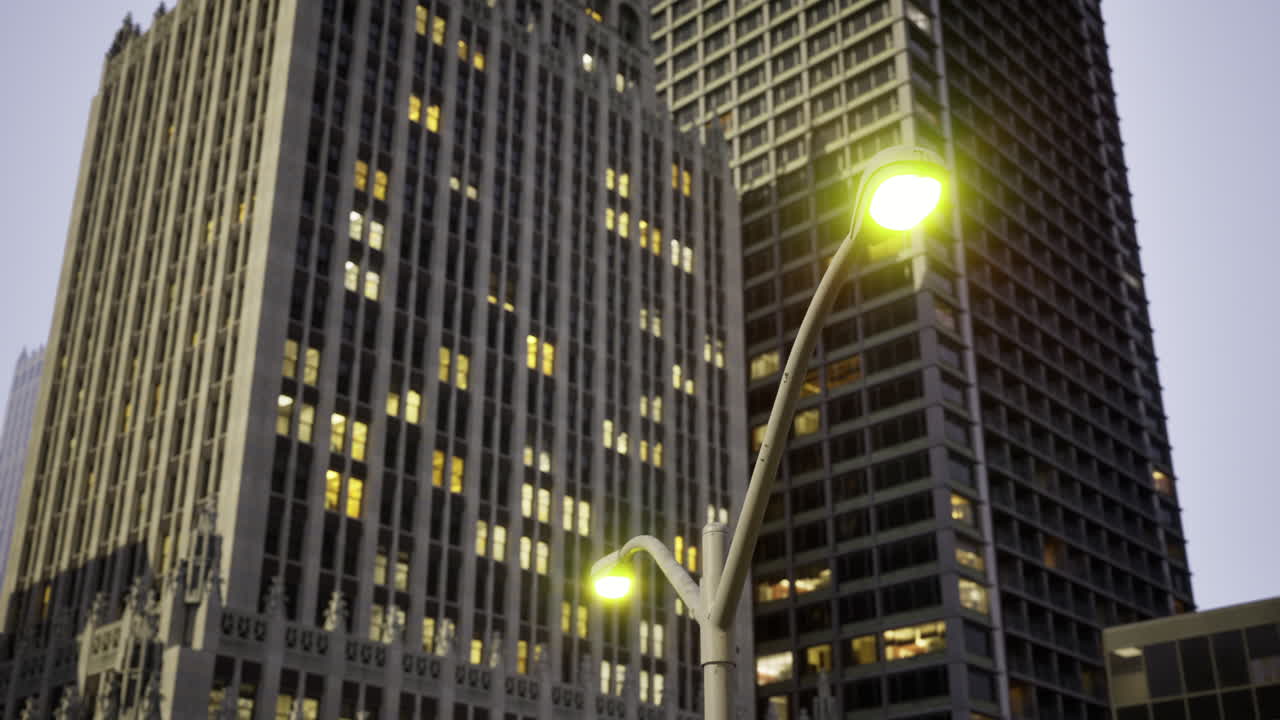 City buildings illuminated at dusk with streetlights glowing softly