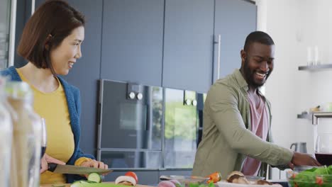 Vídeo-De-Una-Pareja-Feliz-Y-Diversa-Preparando-Comida-Y-Sonriéndose-En-La-Cocina-De-Casa