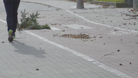 a man runs along a path among branches and shifting leaves - windy weather