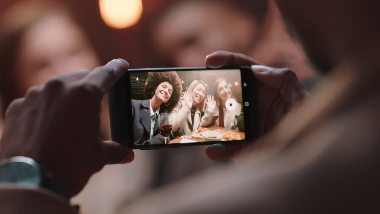 hombre de cerca usando un teléfono inteligente tomando fotos de amigos celebrando haciendo un brindis compartiendo una fiesta de celebración en las redes sociales disfrutando haciendo recuerdos