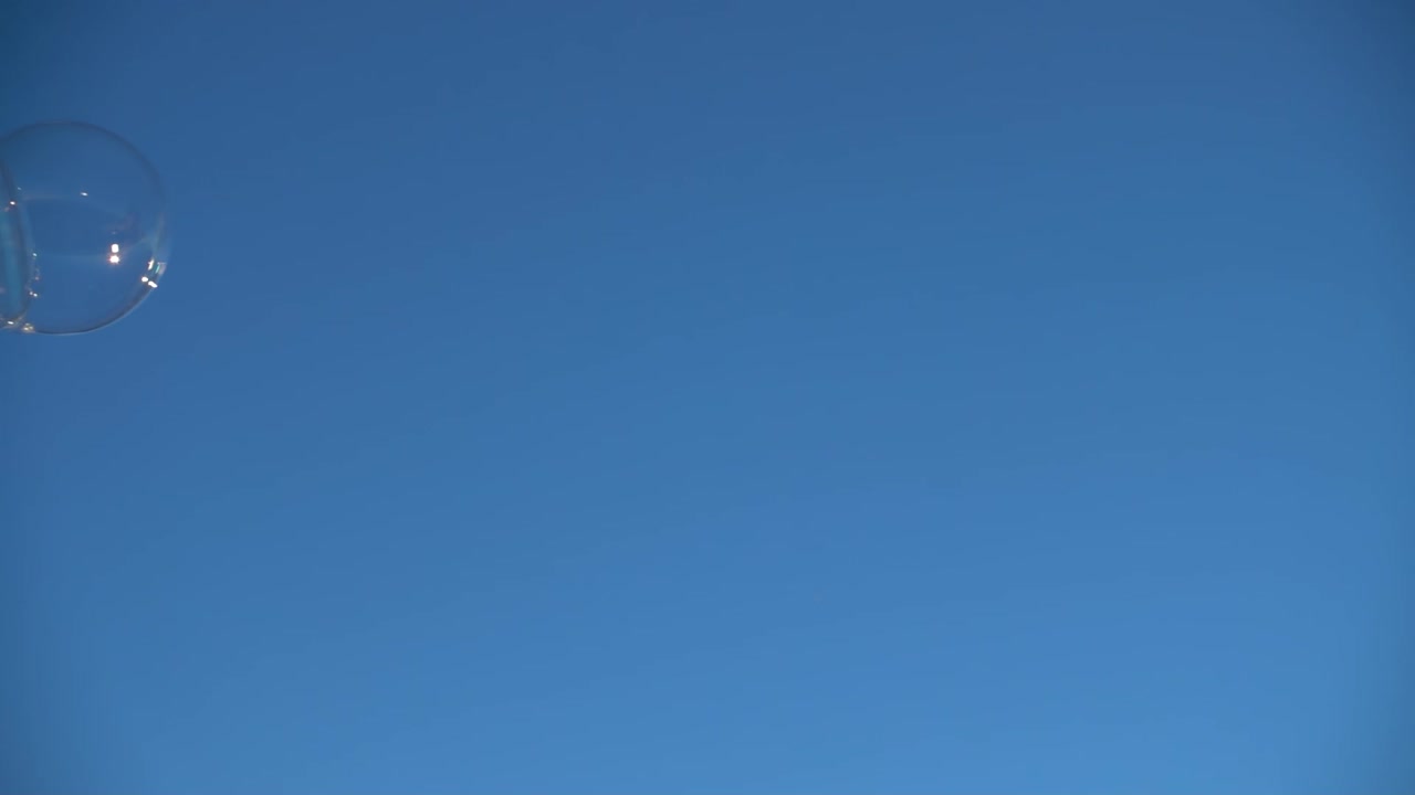 Soap bubbles against the background of the sky. Slow motion