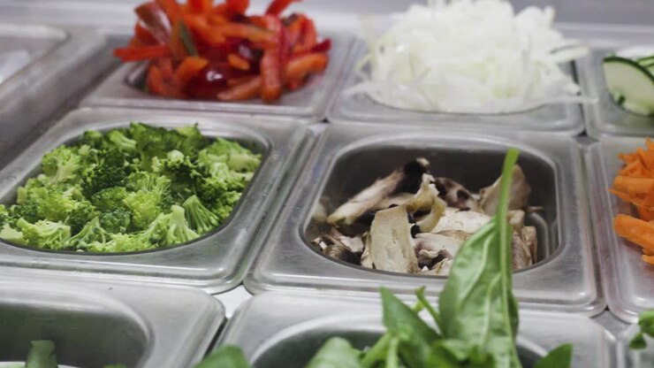 Pan shot of fresh vegetables on steel trays on a healthy food on the go