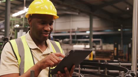 Worker-using-digital-tablet-in-bottle-factory