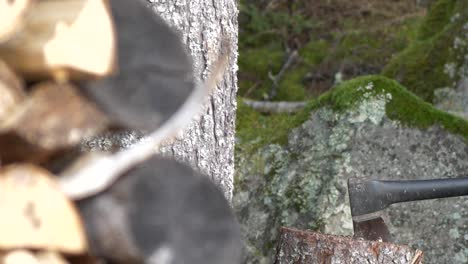 Axe-splitting-lumber-firewood-in-slow-motion,-handheld