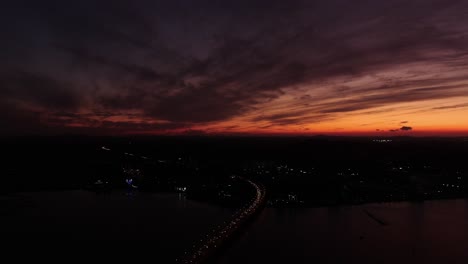 Eine-Brücke,-über-Der-Die-Sonne-Untergeht-Und-Einen-Panoramablick-Auf-Das-Meer