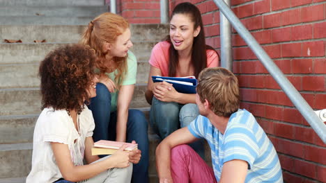 Glückliche-Studenten-Sitzen-Auf-Stufen-Und-Unterhalten-Sich