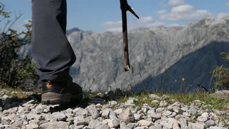 Man-hiking-in-the-mountains-with-trekking-shoes-and-walking-stick,-closeup