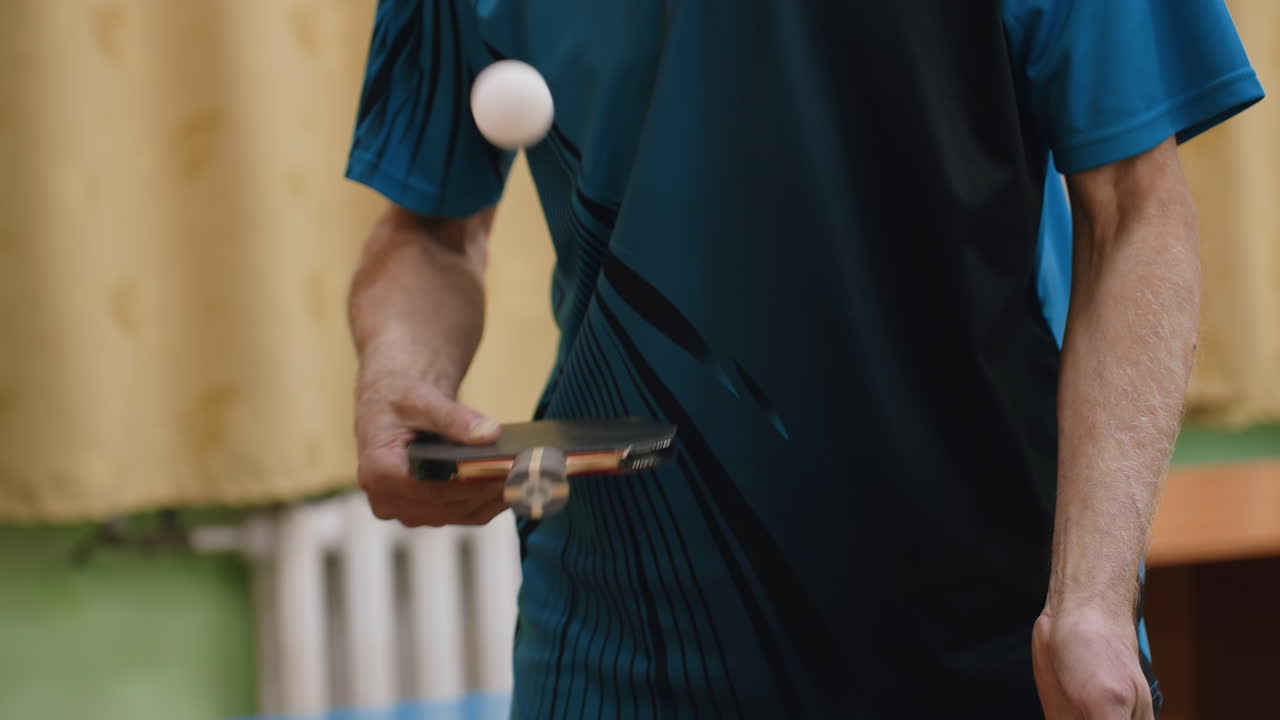 Close up of player holding racket handle to practice tennis indoors, focusing on grip and precision while blurred background emphasizes control, discipline