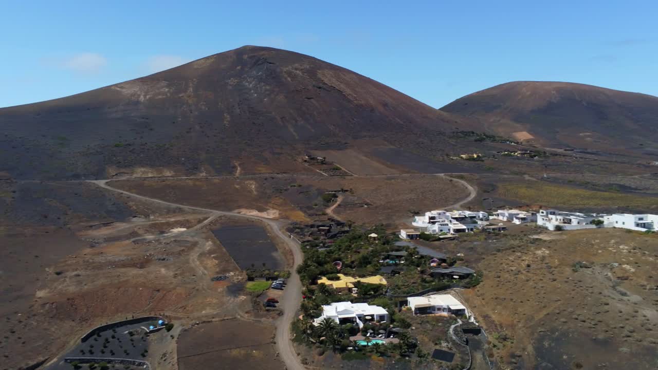 camino rural y pequeño pueblo cerca de la majestuosa montaña en lanzarote, vista aérea de drones