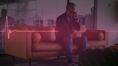 animation of heart rate monitor over caucasian senior man talking on smartphone at office