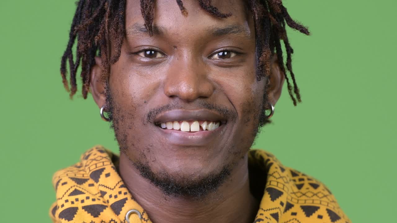 Giovane uomo africano felice su sfondo verde