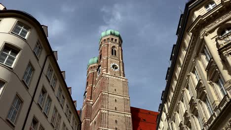 frauenkirche church between buildings in city center of munich at sunny day