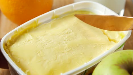 Fresh-butter-in-a-container-with-bread-on-white-background