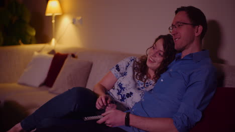 Young-Couple-Watching-Tv-At-Home-Siting-On-Softa-In-Living-Room-1