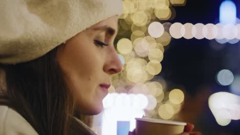 close up video of woman drinking mulled wine on cold night.